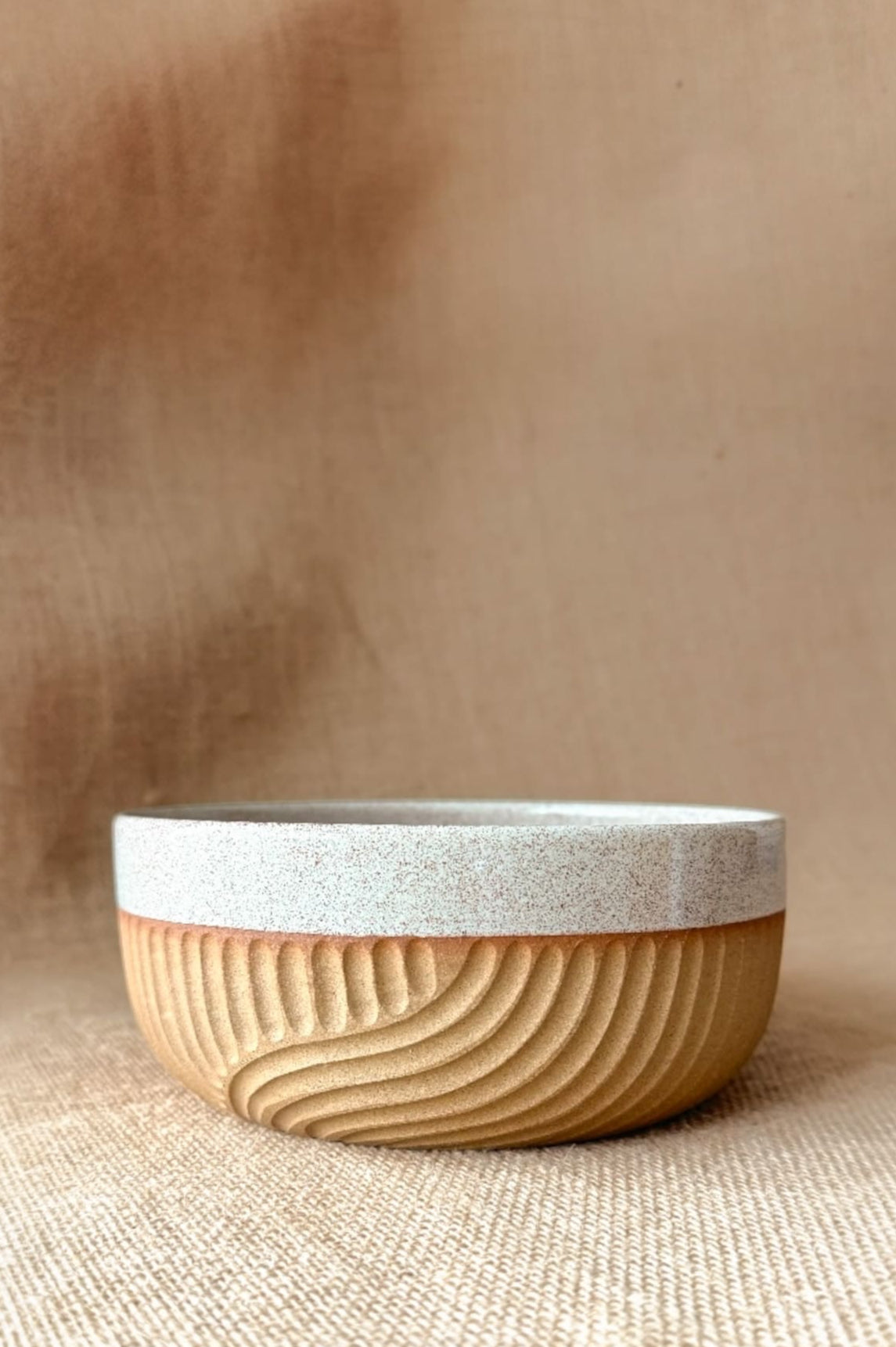 Ceramic bowl with textured surface on a beige background