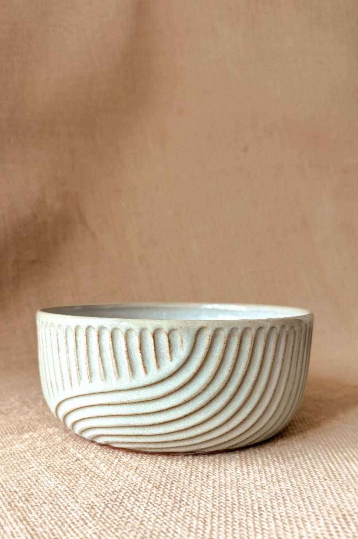 Ceramic bowl with textured design on a beige background