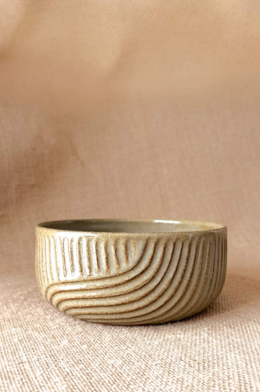 Ceramic bowl with textured design on a beige background