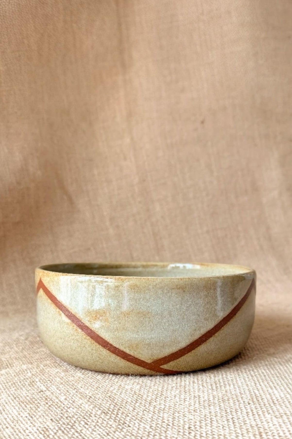 Ceramic bowl with a decorative stripe on a beige background