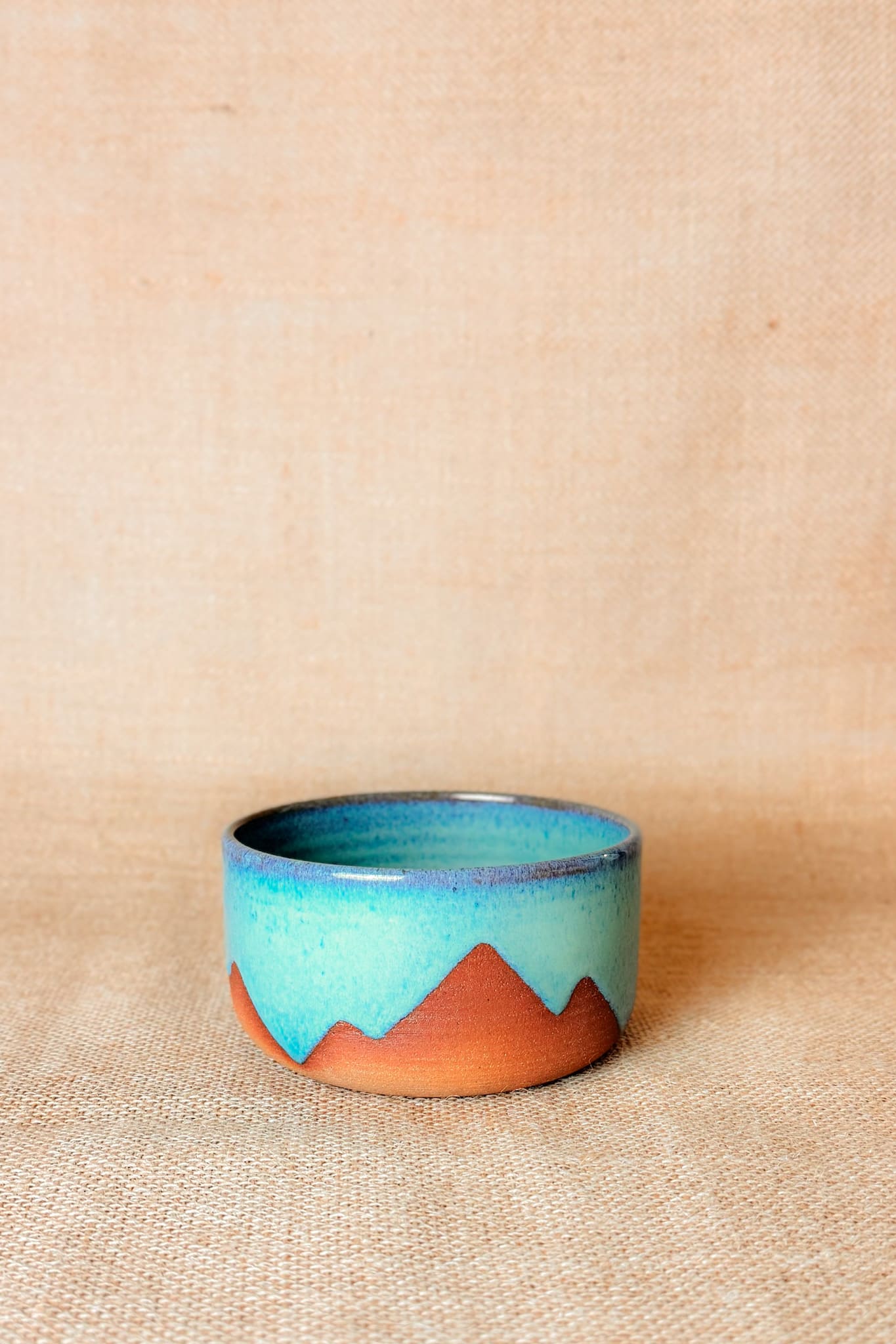 Ceramic bowl with blue and brown gradient on a beige background